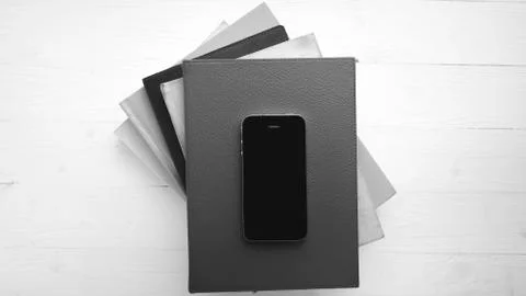 Cellphone with stack of book black and white tone color style Stock Photos