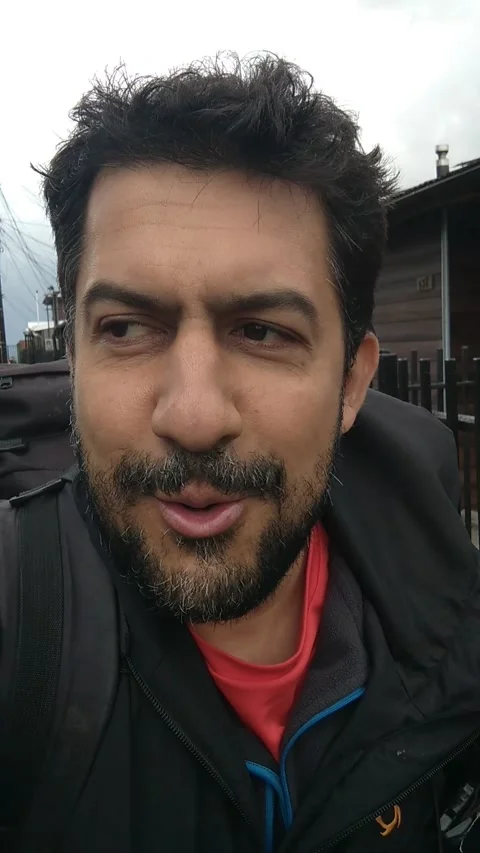 Cellphone vertical video from a man walking and talking directly to camera while Stock Footage 161079386