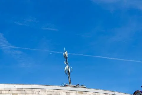 Cellular 5G tower broadcasting network signal under blue sky Stock Photos