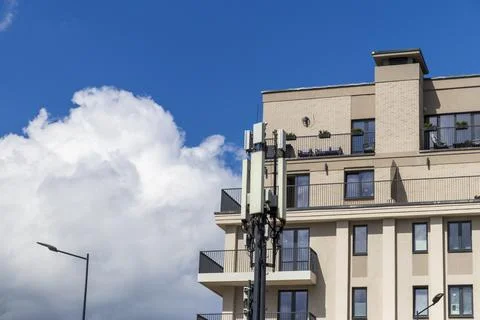 Cellular base station antennas installed next to a modern apartment buildin.. Foto stock