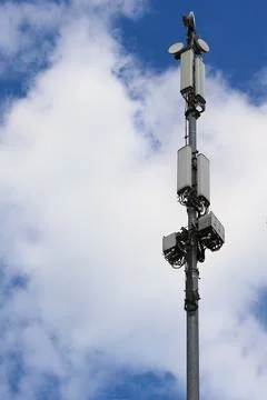 Cellular Communication Tower Against Cloudy Blue Sky Stock Photos
