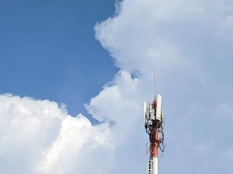 Cellular Communication Tower and Cloudy Blue Sky 스톡 사진