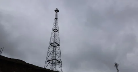 A cellular communication tower standing tall on a hilltop against the open sky Video stock 335554759