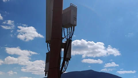 Cellular LTE antenna and microwave dish on tower with mountains Stock Footage 337952605