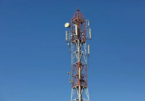 Cellular, mobile phone transmitter tower and weather station with blue sky Stock Photos
