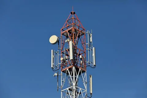 Cellular, mobile phone transmitter tower and weather station with blue sky Stock Photos