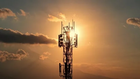 Cellular network tower silhouetted against dramatic sunset with clouds. Stock Footage 344011612