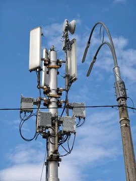 Cellular tower placed next to a streetlight on a short pole along the road Stockfoto's