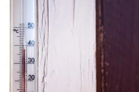 A Celsius thermometer on a window frame of a country house shows temperatures up Stock Photos
