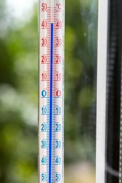 A Celsius thermometer on a window frame shows high temperatures of 43 degrees Stock Photos