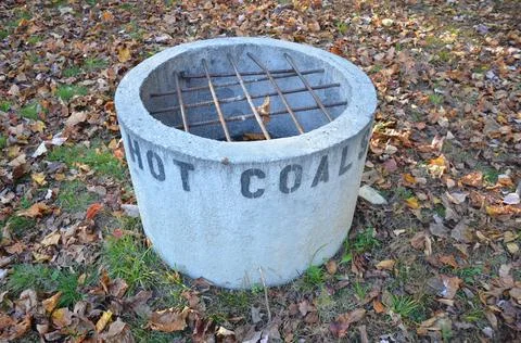 Cement hot coal fire pit with metal grate Stock Photos