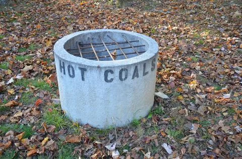 Cement hot coal fire pit with metal grate Stock Photos