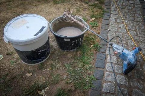 Cement is mixed in a bucket with a stirring machine. Stock Photos