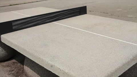Cement ping pong table outside outdoors in courtyard on cement spheres Stock Footage 248710696