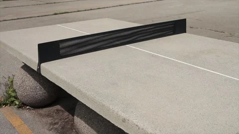 Cement ping pong table outside outdoors in courtyard on cement spheres Stock Footage 248710814