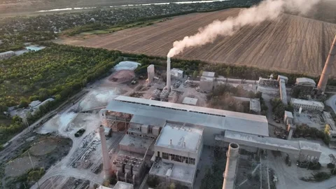Cement plant stack plume beside farmland in a drone aerial view. Construction Stock Footage 346923632