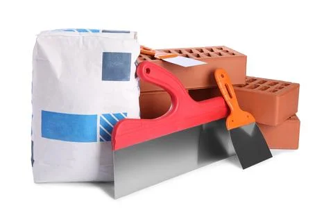 Cement powder in bag, red bricks and putty knives isolated on white. Buildi.. Stock Photos