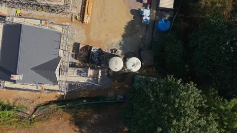 Cement silos on construction site as drone descends in top-down aerial view Stock Footage 345669309