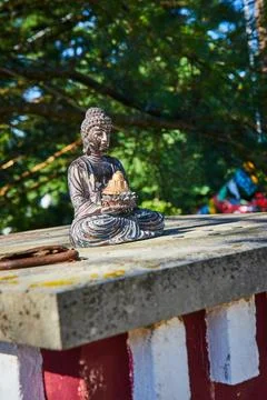 Cement square with small Buddhist statue resting on top Foto stock