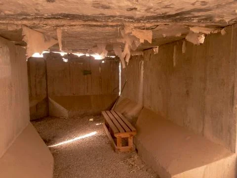 Cement t-wall bunker interior with wooden bench Stock Photos