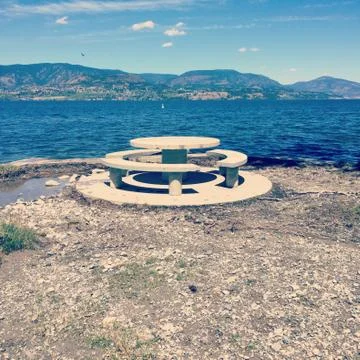 Cement table and seating area on lakeshore Stock Photos