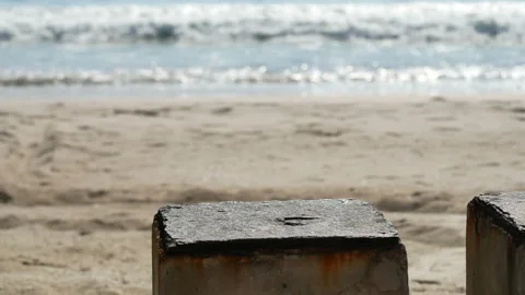 Cement table on sand beach , sea wave hit shore, reflection and bokeh light i Stock Footage 132020033