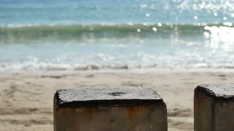 Cement table on sand beach , sea wave hit shore, reflection and bokeh light i Stock Footage 132020142