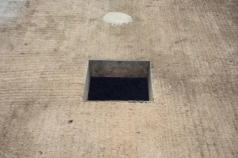 Cement wall with rectangle hole sewerage and electricity wiring Stock Photos