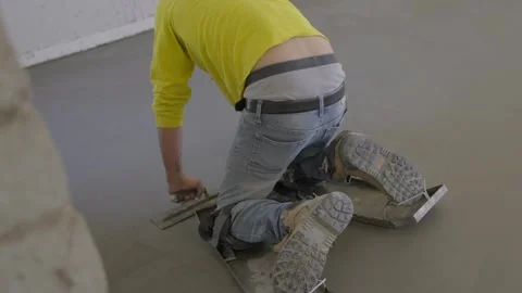 Cement worker using trowel to smooth out floor Stock Footage 292911563
