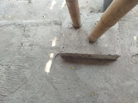 Cemented bamboo house support pillars on the ground Stockfoto's