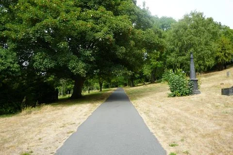 Cemetery Path Lined With Green Trees And Gravestones In Sheffield, England. Foto stock