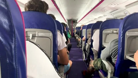Center aisle of the plane during the flight with people sitting during the day 스톡 동영상 246332244