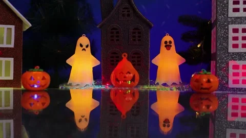 In the center of the small town, amidst glowing pumpkins, stands a gray house 스톡 동영상 346601666