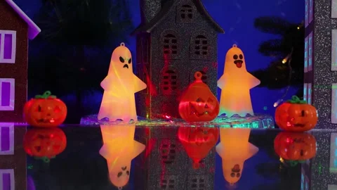 In the center of the small town, amidst glowing pumpkins, a grey house 스톡 동영상 346601686