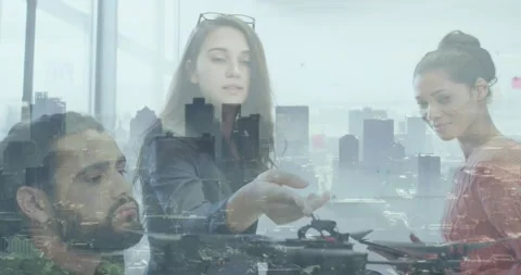 Center woman handing component, tech team assembling drone for testing in Stock Footage 330577465