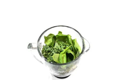 Centered Close Up of Green Kale &amp; Spinach in the Glass of an Uncovered Blender Stock Photos