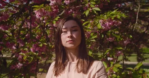 Centered frame of an asian girl looking deeply in the camera. Spring in Stock Footage 246722874
