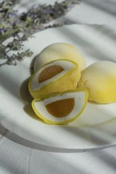 Centered Mango Mochi Cut on White Plate with Dark Background Stock Photos