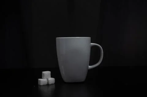 Centered mug with sugar cubes, dark gradient backdrop Stock Photos