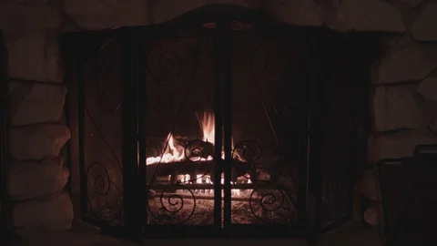 Centered shot of a dark fireplace with a dying fire inside. Stock Footage 88708774