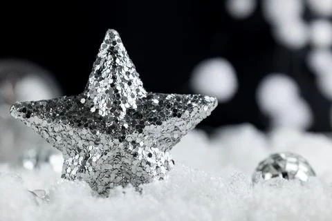 Centered silver glitter Christmas star in snowy foreground with black backg.. Fotos Stock