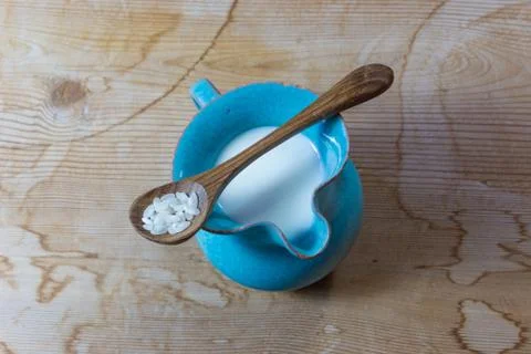 Centered view of a small blue ceramic pitcher of rice milk with wooden spoon Stock Photos