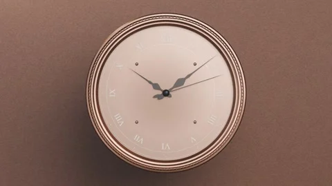 Centering camera showing analog clock with metallic rim on warm brown wall, Stock Footage 337505105