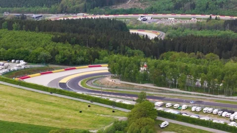 Centers light blue car threading tight curve beside clustered caravans slopes Stock Footage 327953616