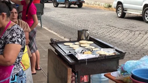 Central American lady preparing corn tortillas at a sidewalk in Salvador Stock Footage 76670431