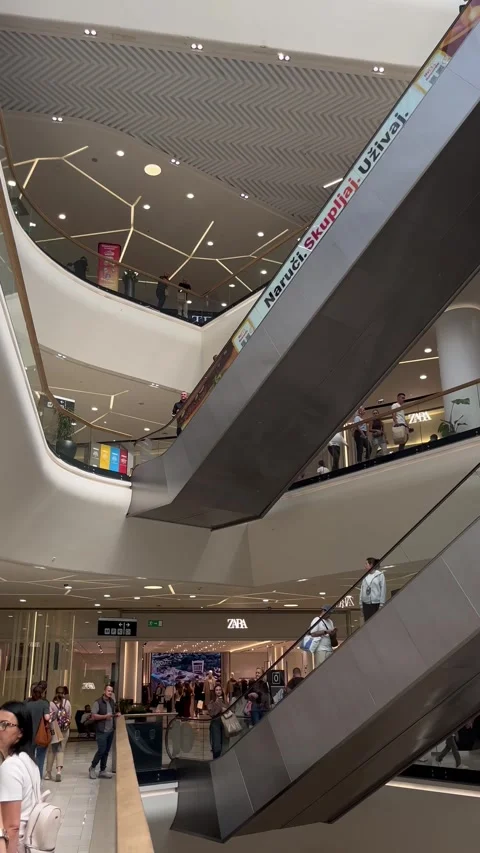 Central Escalators and Shoppers Inside BIG FASHION Novi Sad Shopping Mall Stock Footage 346547225