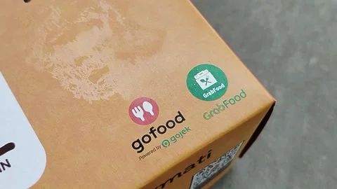 Central Java 14 April 2026: Food packaging featuring GoFood and GrabFood deliver Stock Footage 333503619