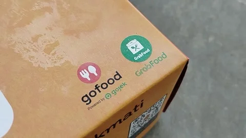 Central Java 14 April 2026: Food packaging featuring GoFood and GrabFood deliver Stock Footage 333503648