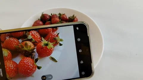 Central Java Indonesia 13 May 2026: A smartphone camera capturing fresh strawber Stock Footage 336289380
