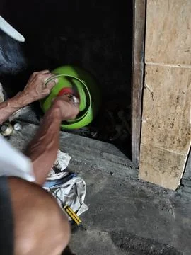 Central Java Indonesia 19 July 2026: A person repairing an LPG gas cylinder for  Stock-Fotos